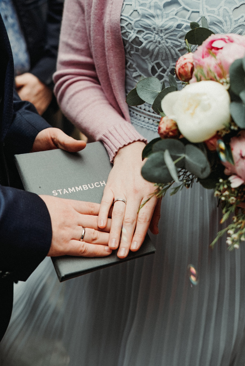 hochzeitspaar-eheringe-stammbuch-natuerliche-hochzeitsfotografie